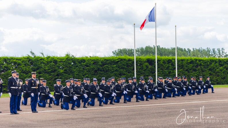 Agrandir l'image Une promotion d'élèves-gendarmes rassemblée genou à terre devant le drapeau français