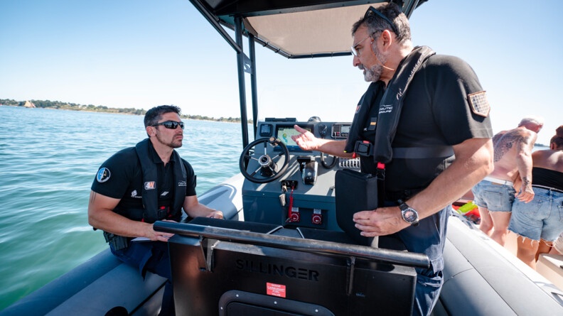 Deux gendarmes de la B.N. de Quiberon échangent à bord du semi-rigide de l'unité lors d'un contrôle en mer.