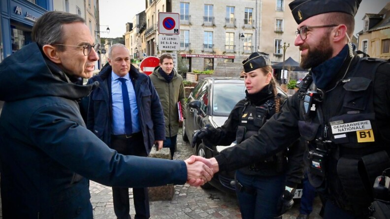 Le ministre de l'Intérieur serrant la main à un gendarme mobile.