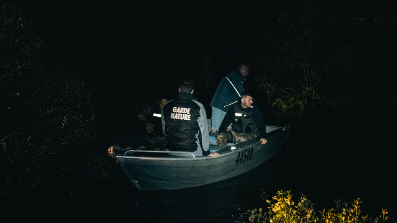 Gardes nature et gendarmes à bord d'une embarcation de nuit.