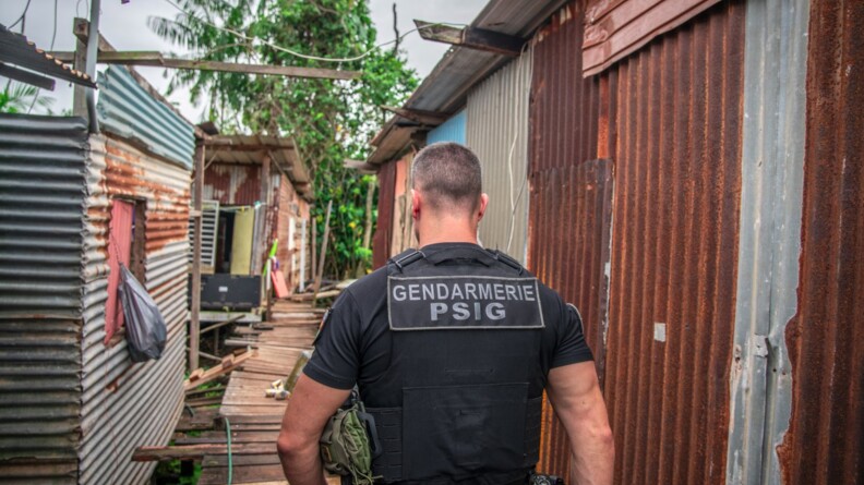Gendarme du PSIG de Matoury de dos dans un quartier informel.