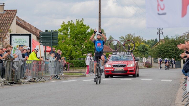 Agrandir l'image Un cycliste vainqueur à l'arrivé du 25e championnat de France de cyclisme gendarmerie lève les doigts vers le ciel.