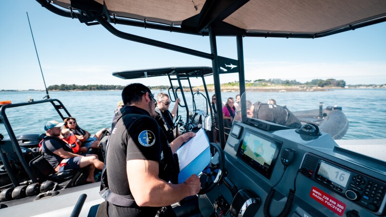 Contrôle en mer d'une embarcation à moteur par la brigade nautique de Quiberon. Le gendarme vérifie les papiers du bateau.