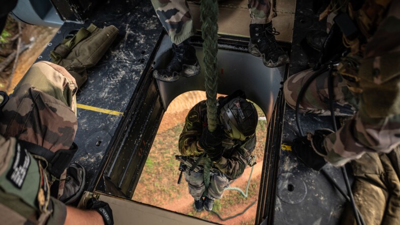Militaire descendant en corde lisse depuis le puits de l'hélicoptère Puma.