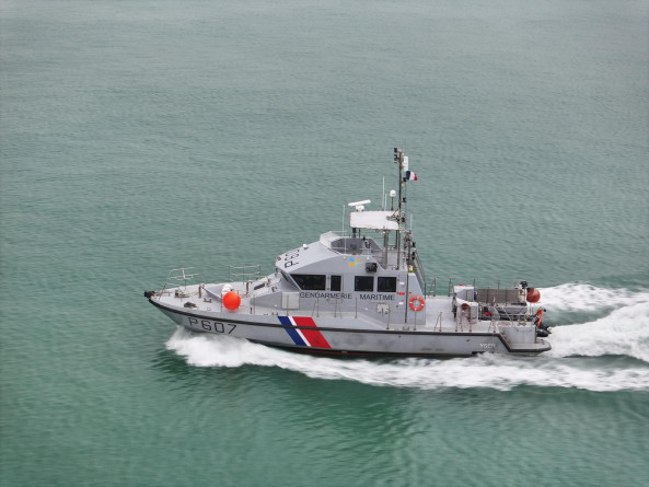 Agrandir l'image La vedette côtière de surveillance maritime (VCSM) Yser, identifiable par son immatriculation "P607", navigue à vive allure sur une mer calme et verte. Le bateau est de couleur grise avec des marquages tricolores bleu, blanc et rouge sur la coque, et l’inscription « GENDARMERIE MARITIME » sur le flanc. On distingue plusieurs équipements de navigation sur le pont, un drapeau français hissé en haut du mât, ainsi que des bouées de sauvetage orange fixées à bord. Quelques membres d’équipage sont visibles à l’arrière.