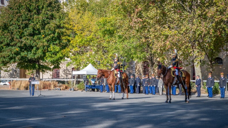 A gauche, une femme général de la Garde républicaine lisant un ordre du jour. Au milieu le général commandant la Garde et à droite le colonel Leheup, en grande tenue. En arrière-plan, des officiers de différentes armées