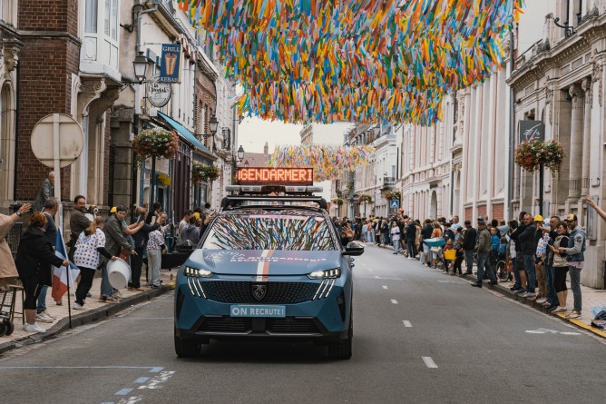 Agrandir l'image Véhicule de la caravane gendarmerie avançant dans une rue.
