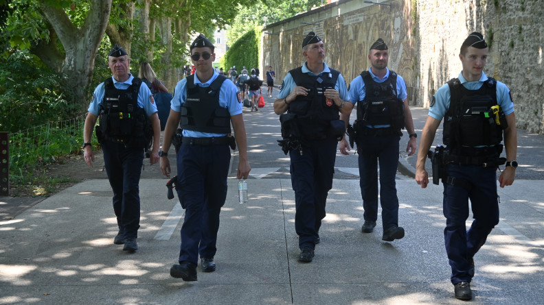 Cinq gendarmes effectuent une patrouille pédestre dans la rue, à l'occasion du festival Garorock. Les cinq militaires avancent côte à côte.