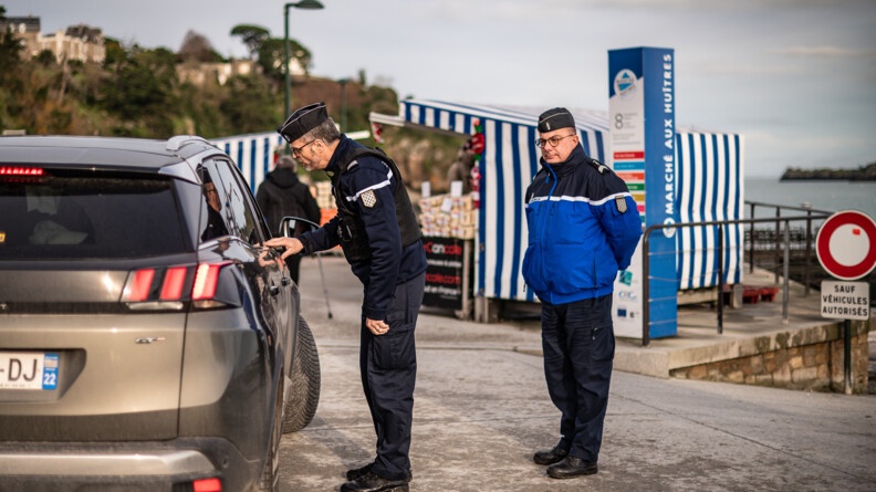 Agrandir l'image Deux gendarmes parlent avec un passager dans un véhicule