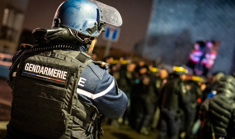 Gendarme de dos face à la foule.