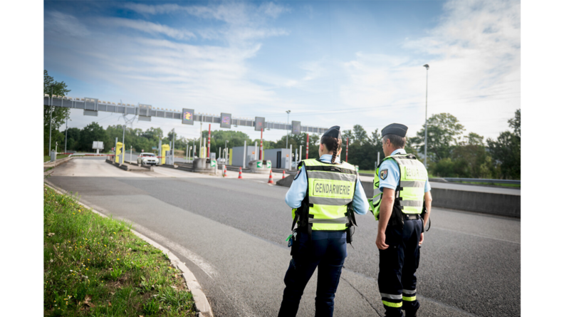 Deux gendarmes de dos devant un péage