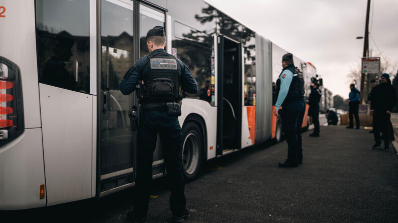 Agrandir l'image Des gendarmes sont positionnés au niveau des portes d'un autobus, alors que celui-ci est arrêté à la station, et que d'autres gendarmes réalisent un contrôle des voyageurs à bord du véhicule.