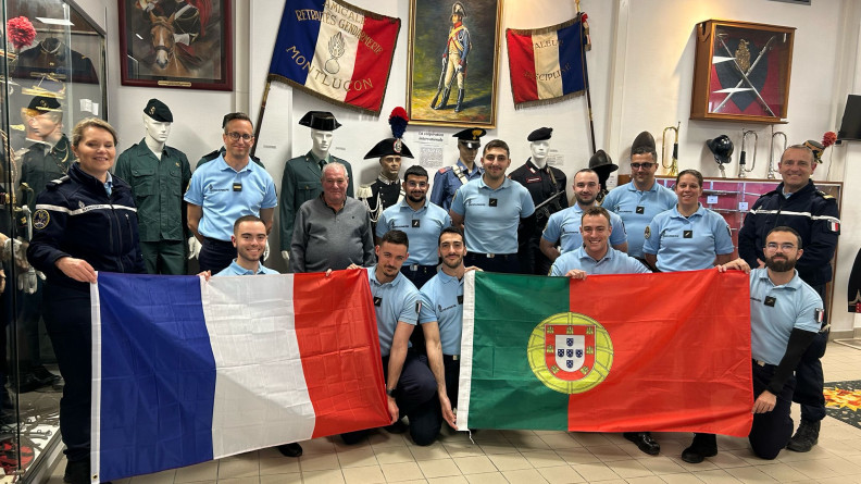 Agrandir l'image Treiez gendarmes français portant les drapeaux français à gauche et portugais à droite, devant un mur couvert de drapeaux et images militaires