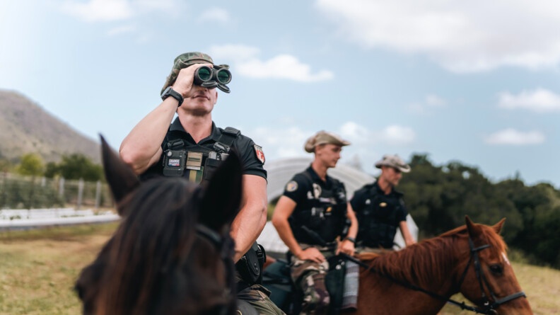Agrandir l'image Gendarme du PSIC observant l'horizon à l'aide de jumelles.