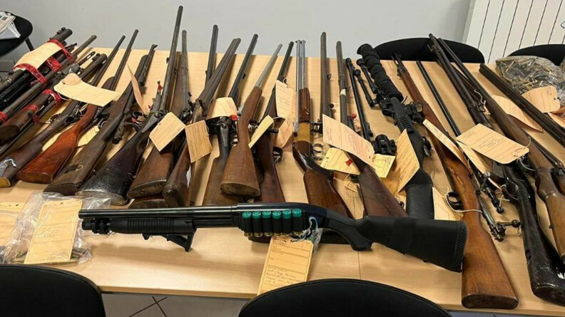 37 armes saisies sous scell&eacute;, sur une table. &agrave; droite, des munitions