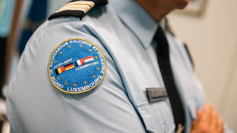 Rondache du Centre de coopération policière et douanière (CCPD) du Luxembourg avec les drapeaux belge, français, allemand et luxembourgeois sur fond de drapeau européen.