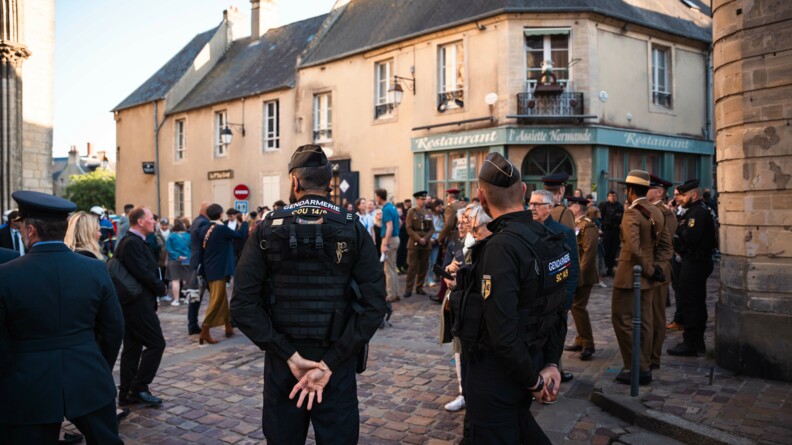 Deux gendarmes sécurisent le parvis de la cathédrale de Bayeux où se trouve de très nombreuses personnes parmi lesquelles plusieurs autorités.