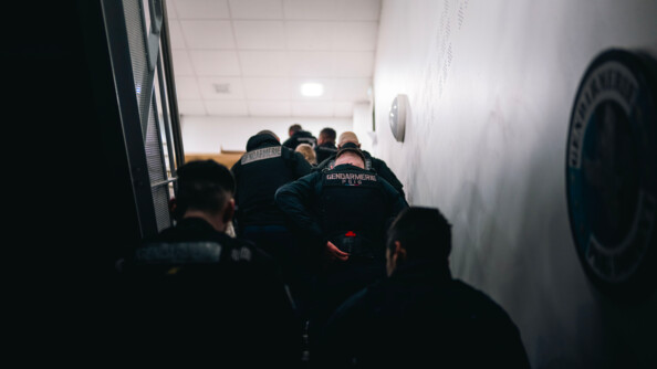 Les gendarmes en groupe, remontent un escalier. Ils se préparent à partir.