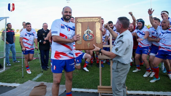 un général de brigade remet au capitaine du XV gendarmerie le trophée du championnat de France militaire de rugby devant son équipe regroupée