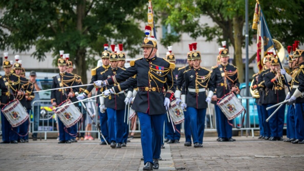 Des gardes de la garde républicaine donnent un concert sur un parvis. Les militaires tapent sur des tambours