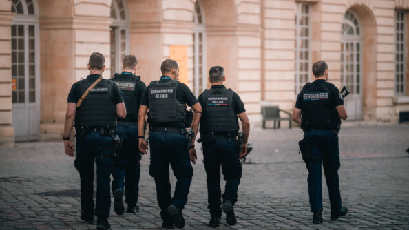Cinq gendarmes de dos dont deux gendarmes de l'air patrouillent devant le château de CHambord