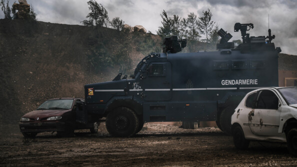 Venant de la droite, n Centaure de la gendarmerie repousse un véhciule épave bordeaux. A droite, une seconde épave blanche. En arrière plan un talus