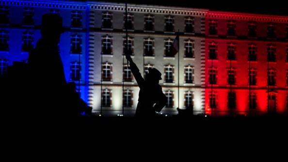 Major tambour dirige la musique - personnes sont en obres chisnoises devant l'atat-major illuminé de bleu blanc rouge