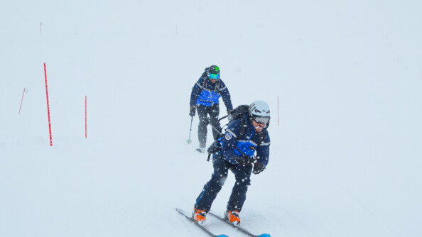 Deux gendarmes descendent en ski sous la neige