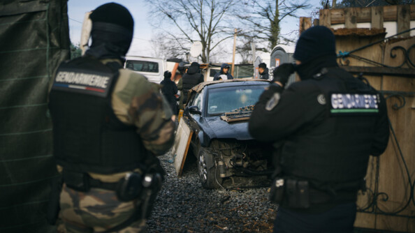 Deux gendarmes de dos faisant des perquisitions dans une décharge.