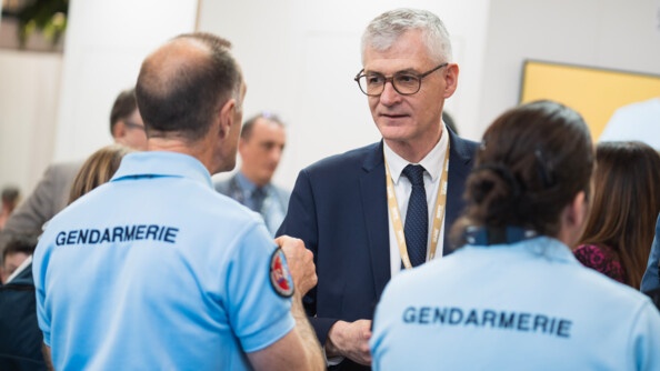 Deux gendarmes de dos sont entrain de parler avec un agriculteur.