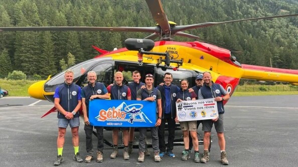 Les randonneurs posent devant l'hélicoptère en arborant les deux banderoles des Képis Pescalunes et de Sebio SSM.
