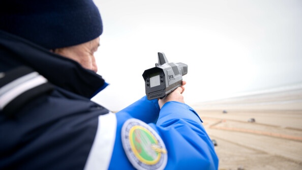 Photo d'un gendarme réserviste de la lutte anti drone (LAD) tenant un pistolet permettant de neutraliser les drones ennemis. Il est de dos et pointe le pistolet en l'air.