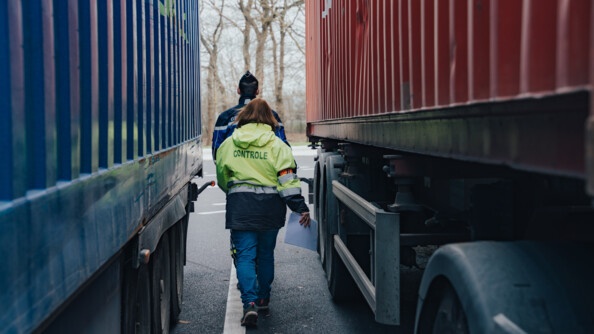 Un gendarme et une agent des douanes entre deux camions