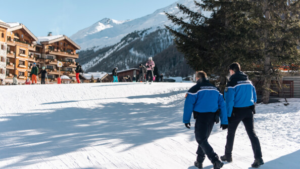 Sous le soleil dans la station de Val d'Isère, deux gendarmes de la brigade réalisent une patrouille pedestre.