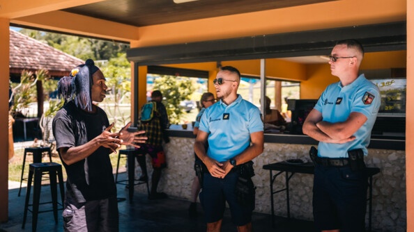 Gendarmes mobiles échangeant avec un responsable du site accueillant les croisièristes à Lifou.