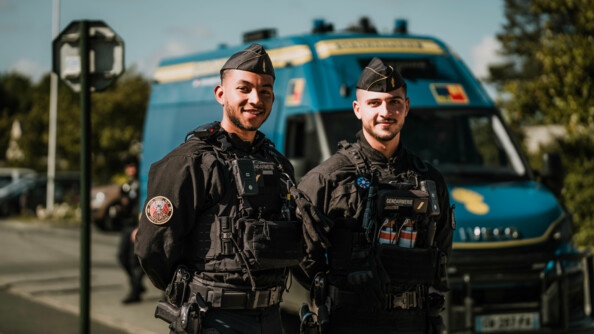 Deux gendarmes mobiles devant un iris bus, les camions de transports de la gendarmerie.