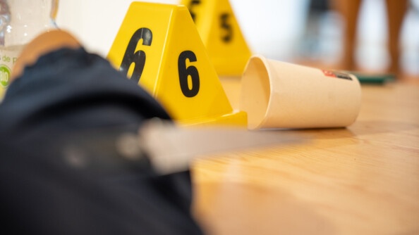Zoom sur un plot jaune portant en noir le numéro 6 posé près d'un gobelet en carton