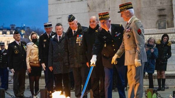 Un g&eacute;n&eacute;ral de gendarmerie, muni de son sabre, et un g&eacute;n&eacute;ral de l'arm&eacute;e de Terre, devant la flamme, entour&eacute;s de plusieurs militaires et personnes en tenue civile.