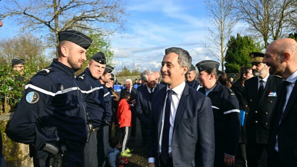 Le ministre de l'Intérieur devant une brigade avec en face de lui plusieurs gendarmes.