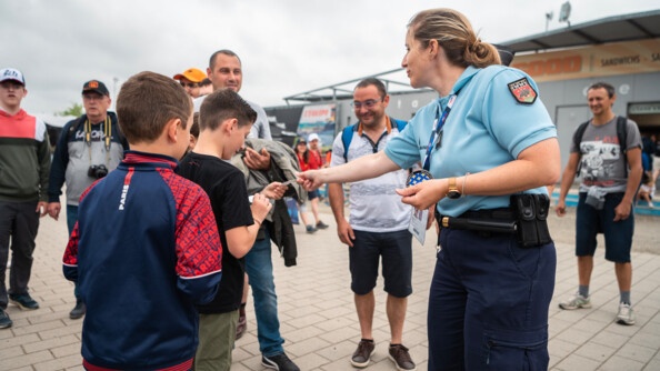 Une gendarme du stand de la GN discute avec des jeunes et des visiteurs