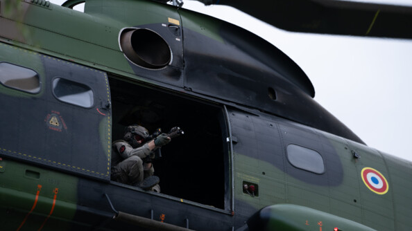 Un tireur d'&eacute;lite du GIGN, arme en joue, assis &agrave; la porte d'un h&eacute;licopt&egrave;re Puma du GIH.