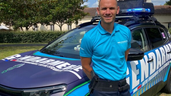 Julien à côté de la voiture gendarmerie de la caravane du Tour de France