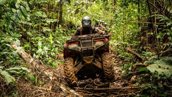 Militaire roulant sur un ensemble de branches avec son quad.
