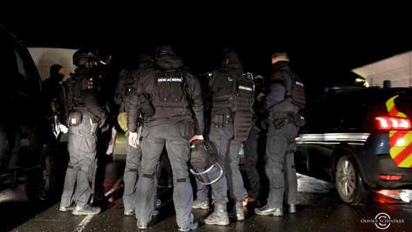 Gendarmes d'unité d'intervention de dos, de nuit.