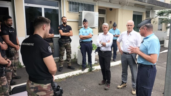 Des gendarmes discutent avec des personnes civiles, debout dans la rue, apr&egrave;s le passage du cyclone Garance sur l'&icirc;le de la R&eacute;union.