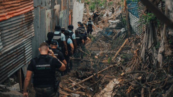 La d&eacute;l&eacute;gation du DGGN marche au milieu des ruines et des bouts de t&ocirc;les.