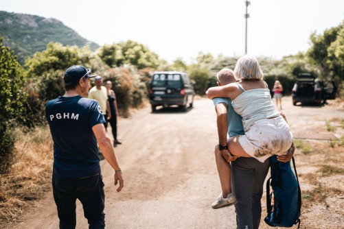 Des gendarmes portent secours à une femme blessée. L'un d'eux porte la femme sur son dos. Ils se dirigent en direction du véhicule de la gendarmerie.