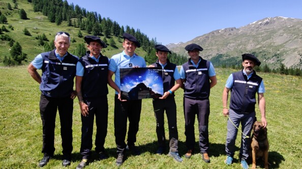 Les gendarmes du PGHM et Nils Allegre sont alignés et présentent le cadre dédicacé par Nils.