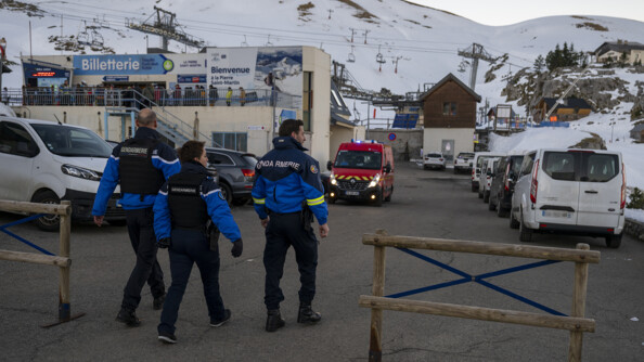Trois gendarmes entrant dans une cour avec des véhicule et un tuilitaire de pompiers