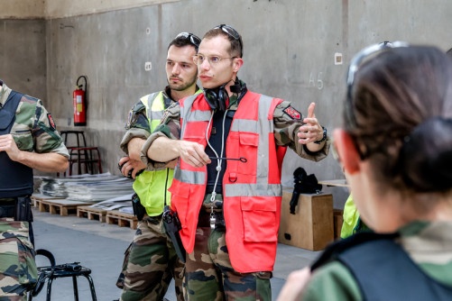 La photo représente un élève en tenue kakie en train de discuter avec une tierce personne